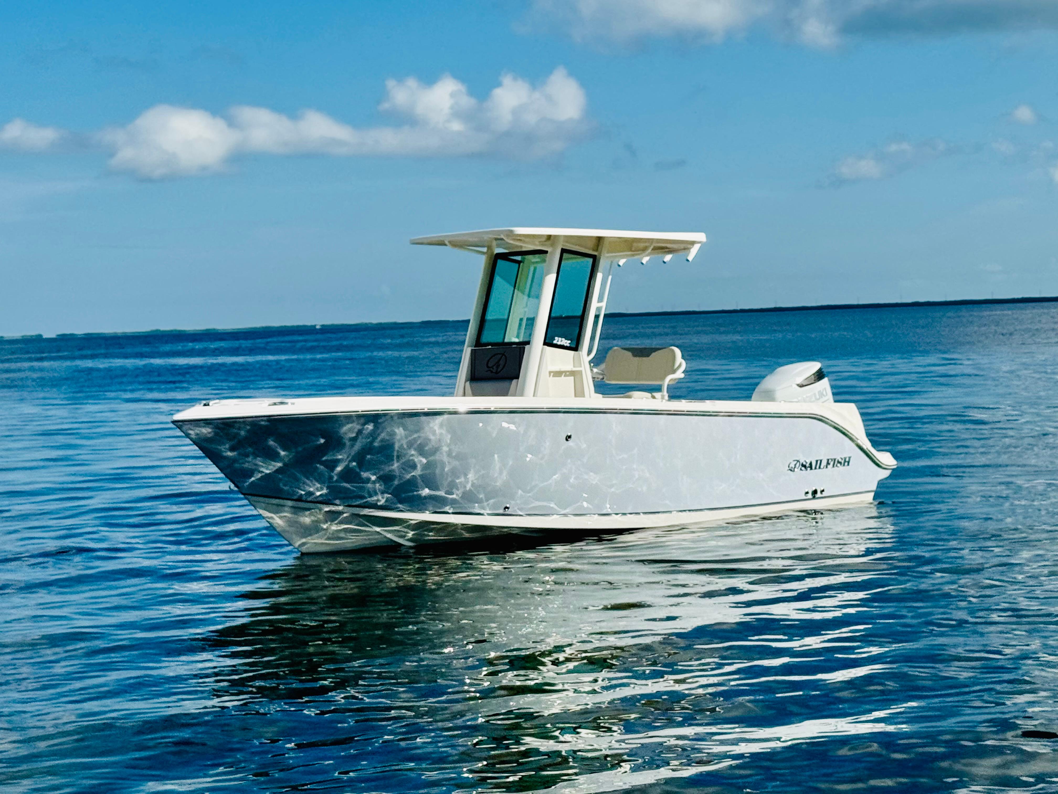 Sailfish 232 CC 2026 Sailfish 232 CC boat on calm ocean waters under a clear blue sky.