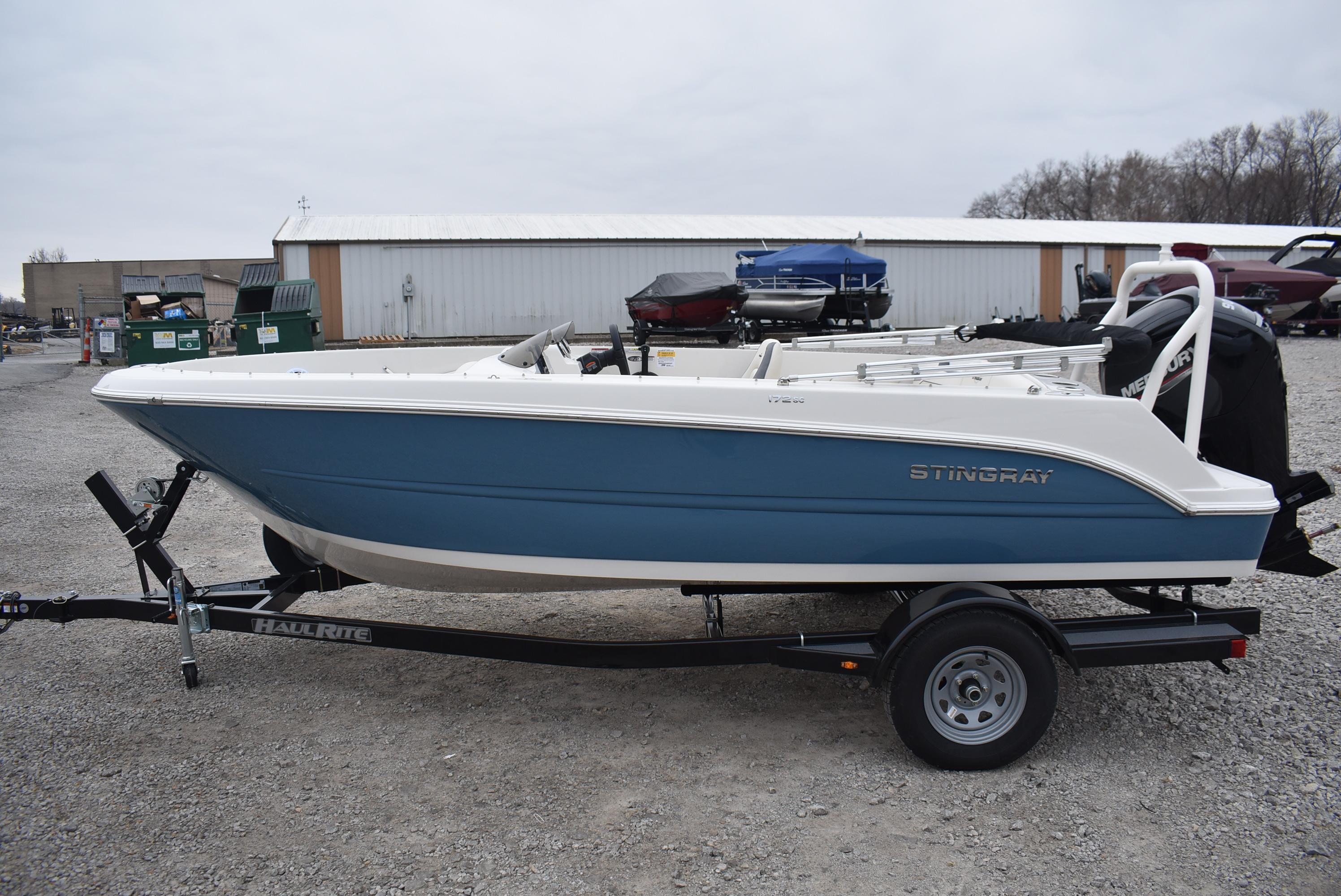 Stingray 172SC 2023 Stingray 172SC boat on trailer, blue and white design, outdoor setting.