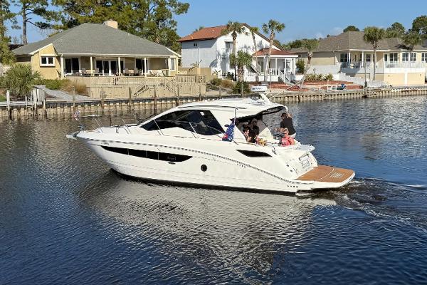 Sea Ray Sundancer 350 Coupe 2021 Sea Ray Sundancer 350 Coupe cruising on a calm residential waterway.