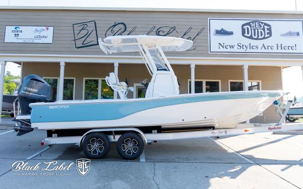 Sea Fox Seafox 251 Bay 2024 Sea Fox Seafox 251 Bay boat on trailer outside a marine store.