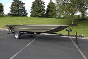 Tracker Grizzly 1860 Utility 2025 Tracker GRIZZLY 1860 Utility boat on trailer in parking lot.