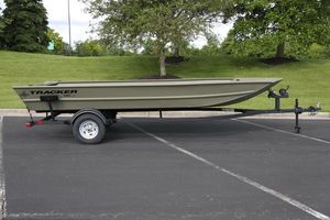 Tracker Grizzly 1860 Utility 2025 Tracker GRIZZLY 1860 Utility boat on trailer in parking lot.