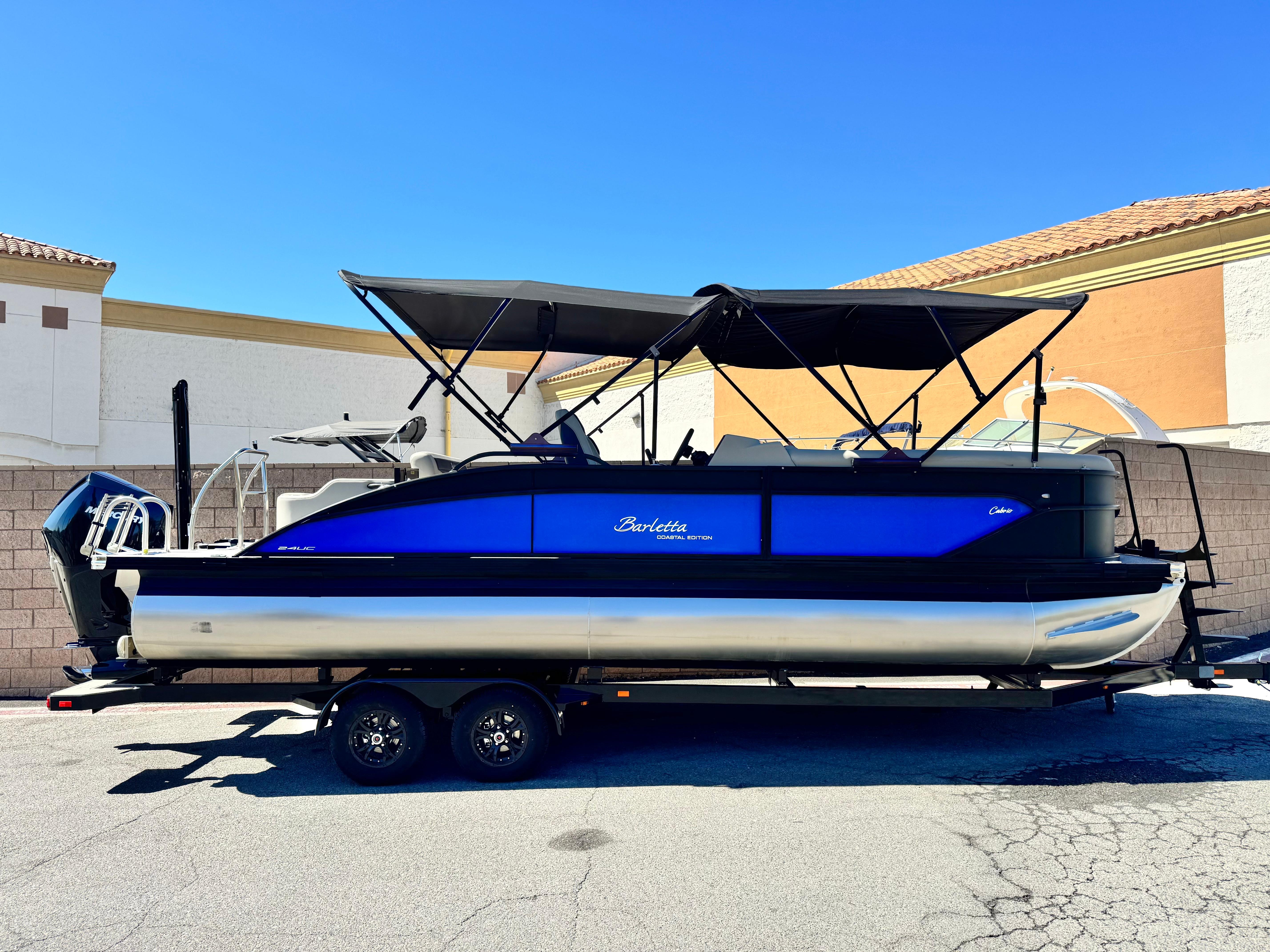 Barletta Cabrio 24UC 2023 Barletta Cabrio 24UC pontoon boat with blue and black design on a trailer.