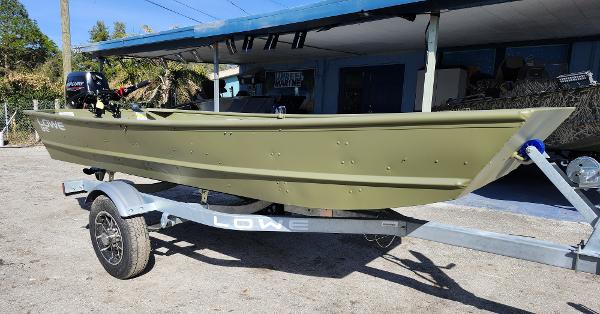 Lowe Jon L1240 2025 Lowe Jon L1240 boat on trailer, parked outdoors in sunny setting.