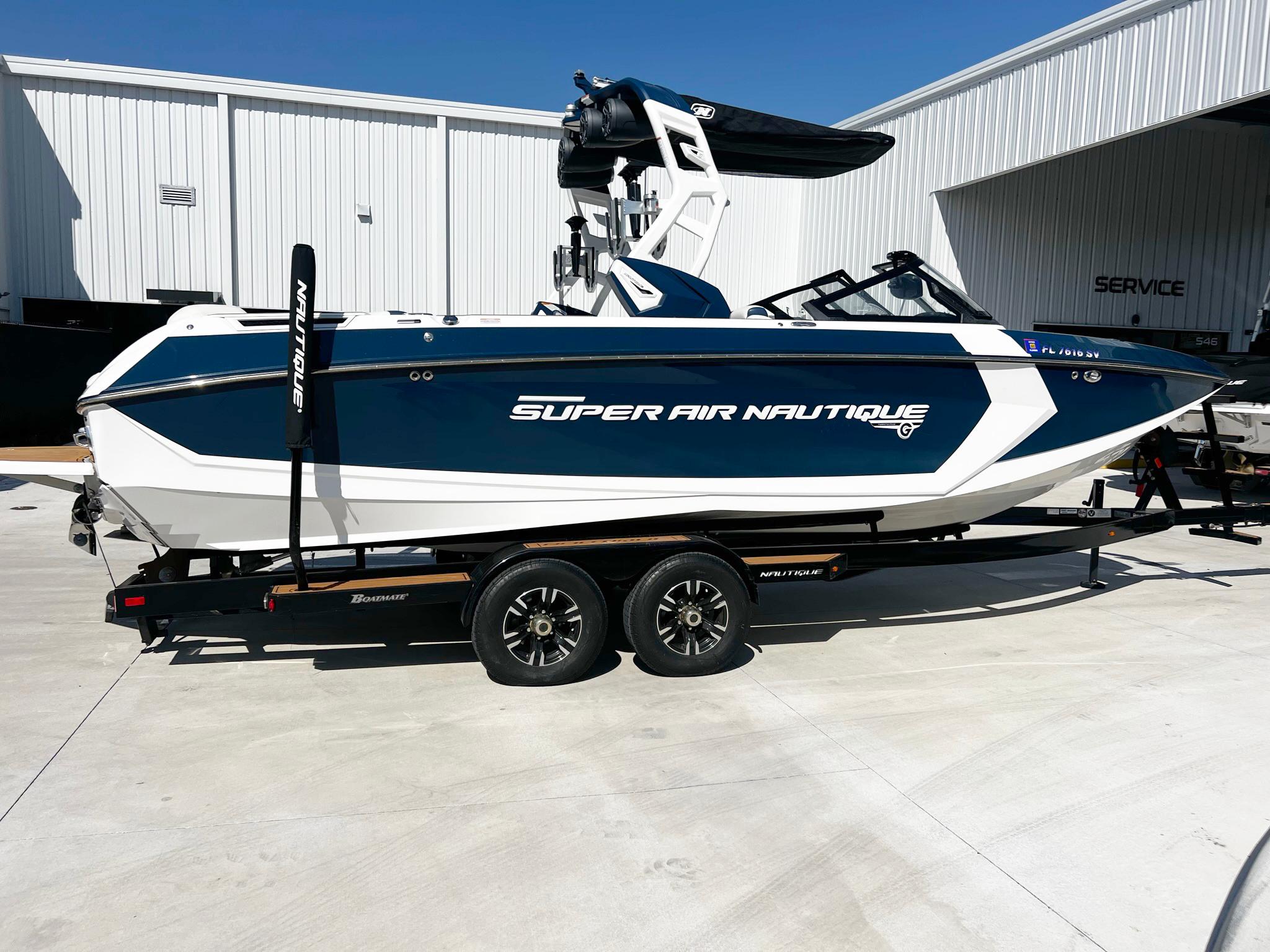 Nautique Super Air Nautique G25 2020 Nautique Super Air Nautique G25 boat on trailer, parked outside a service building.