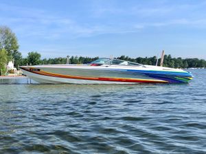 Formula 353 FASTech 2005 Formula 353 FASTech boat with colorful stripes on a calm lake.