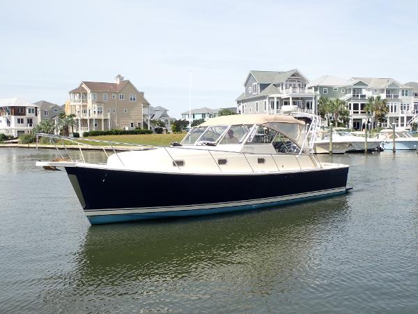 Mainship 34 Rum Runner II 2004 Mainship 34 Rum Runner II yacht docked near waterfront homes.