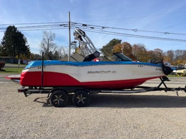 MasterCraft NXT22 2023 MasterCraft NXT22 boat on trailer, red and white design, parked outdoors.