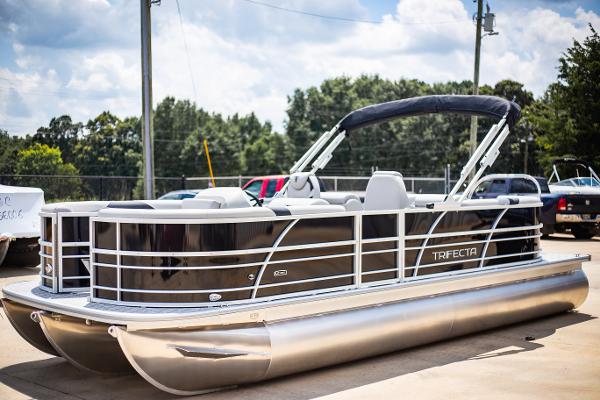 Trifecta 24RF LE 2025 Trifecta 24RF LE pontoon boat parked outdoors on a sunny day.