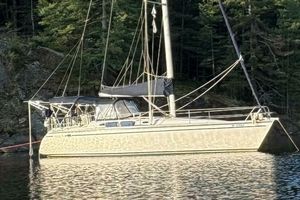 Hunter Legend 37 1989 Hunter Legend 37 sailboat anchored near forested shoreline.