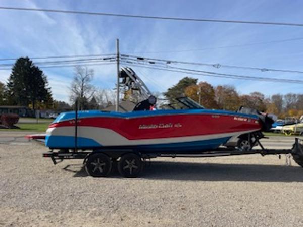 MasterCraft NXT22 2024 MasterCraft NXT22 boat on trailer, vibrant red and blue design.