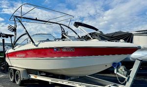 Stingray 220LX 2006 Stingray 220LX boat on trailer, red and white design, parked outdoors.