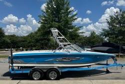 Supra Launch SS 2004 Supra Launch SS boat on trailer, blue with tower, parked outdoors.