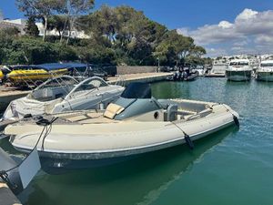 Scanner 950 Envy RIB boat docked in a marina, surrounded by other boats, under a clear blue sky.
