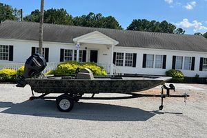 Tracker Grizzly 1648 SC 2026 Tracker Grizzly 1648 SC boat on trailer, parked in front of a white house.