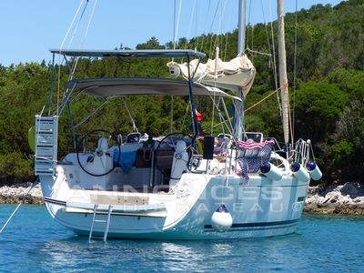 Dufour 380 Sailing yacht Dufour 380, 2013 model, anchored in clear blue waters near a forested shoreline.