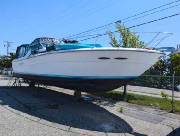 Sea Ray 390 Express Cruiser 1989 Sea Ray 390 Express Cruiser on dry dock, white hull, blue accents, sunny day.