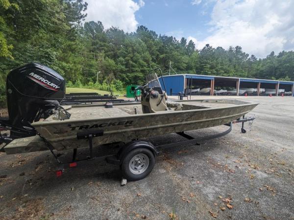 Tracker Grizzly 1860 CC 2025 Tracker Grizzly 1860 CC boat on trailer, parked outdoors near trees and a blue building.