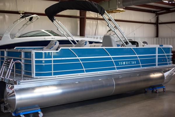 Trifecta 24TRFC LE 2025 Trifecta 24TRFC LE pontoon boat in a showroom, featuring a sleek blue design.