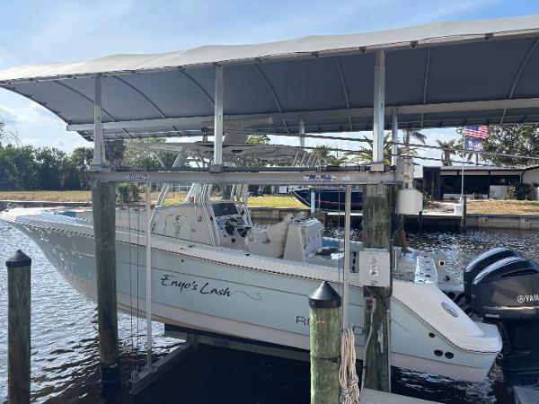 Robalo R300 Center Console 2015 Robalo R300 Center Console boat docked under a canopy with Yamaha engines.