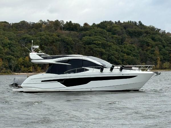 Galeon 510 Sky 2019 Galeon 510 Sky yacht cruising on a scenic river with lush green forest backdrop.