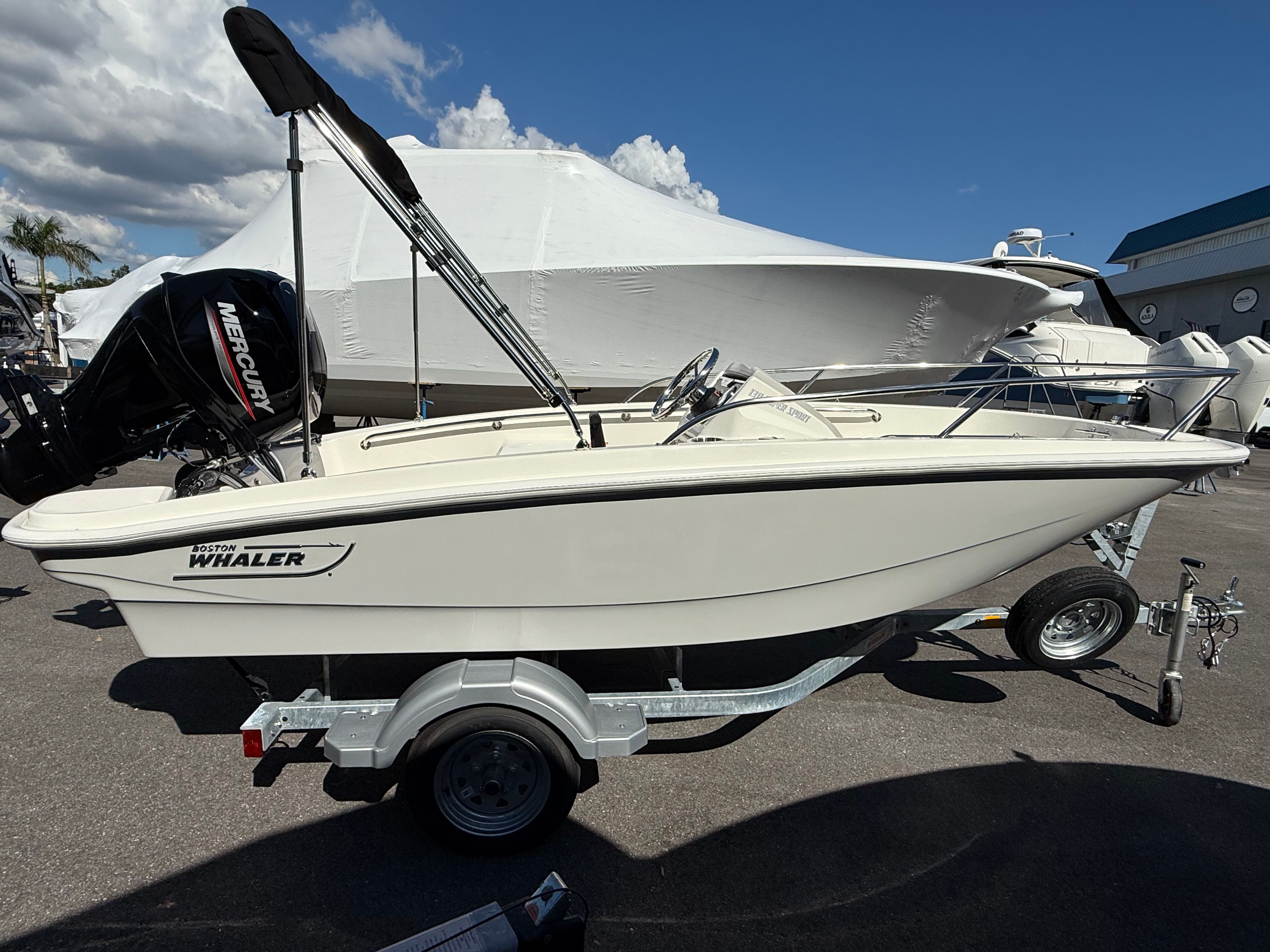 Boston Whaler 130 Super Sport 2024 Boston Whaler 130 Super Sport boat on trailer, side view under clear sky.