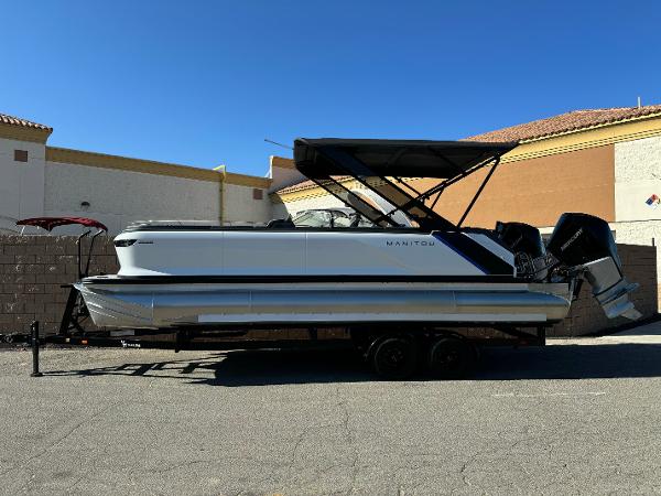 Manitou Explore 24 Switchback Dual SHP With Trifold Bench 2025 Manitou Explore 24 Switchback pontoon boat with trifold bench, parked on trailer.