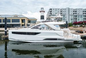 Jeanneau DB|43 Outboard 2024 Jeanneau DB|43 Outboard yacht docked near modern buildings and lighthouse.