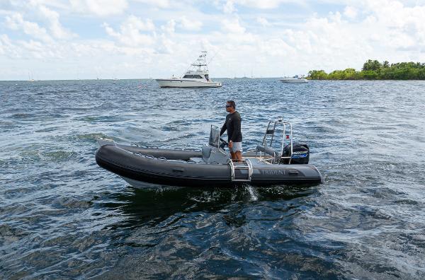 Trident 16 RIB 2023 Trident 16 RIB boat on open water with a person steering.