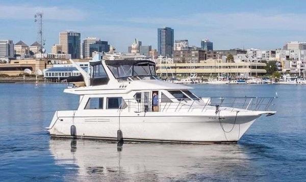 Navigator 4800 2003 Navigator 4800 yacht cruising in a city harbor with skyline backdrop.