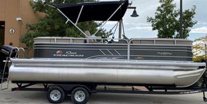 Sun Tracker Party Barge 22 DLX 2025 Sun Tracker Party Barge 22 DLX pontoon boat on trailer, parked outdoors.