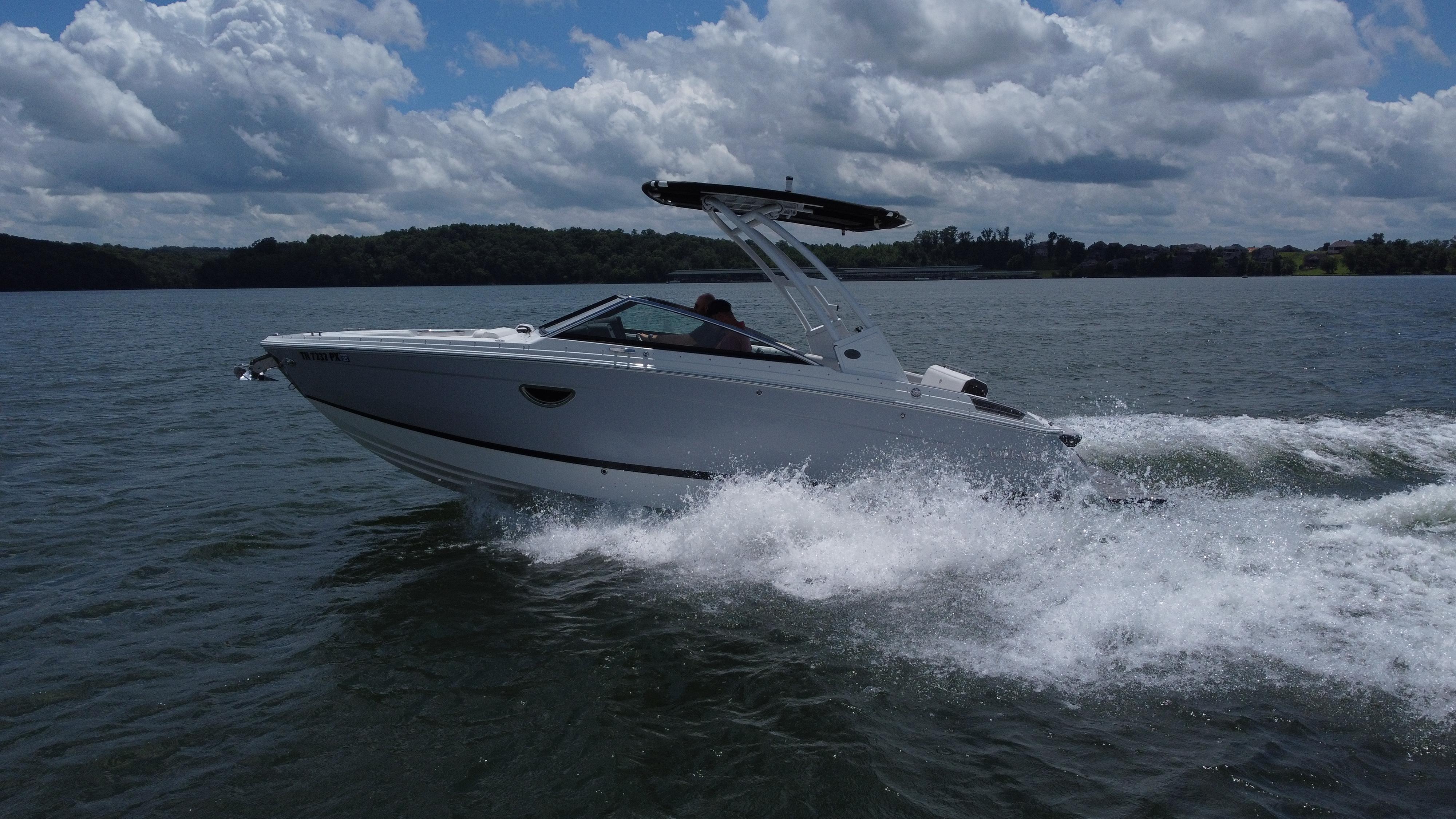 Cobalt R6 2023 Cobalt R6 boat cruising on a lake under a cloudy sky.