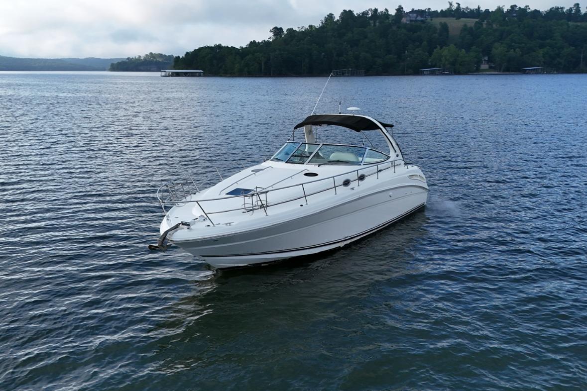 Sea Ray 360 Sundancer 2004 Sea Ray 360 Sundancer cruising on a serene lake with forested shoreline.