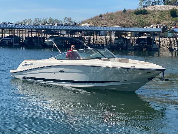 Sea Ray 270 SLX 2012 Sea Ray 270 SLX boat cruising on a calm lake near a marina.