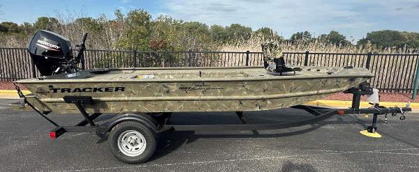Tracker Grizzly 1654 T Sportsman 2025 Tracker Grizzly 1654 T Sportsman boat on trailer, camo design, parked outdoors.