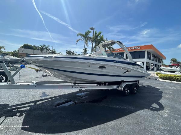 Crownline E290 XS 2024 Crownline E290 XS boat on a trailer at a dealership under a sunny sky.