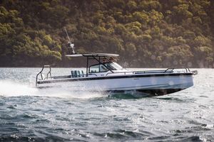 Axopar Axopar 28 T-Top 2024 Axopar 28 T-Top boat cruising on water with lush forest backdrop.