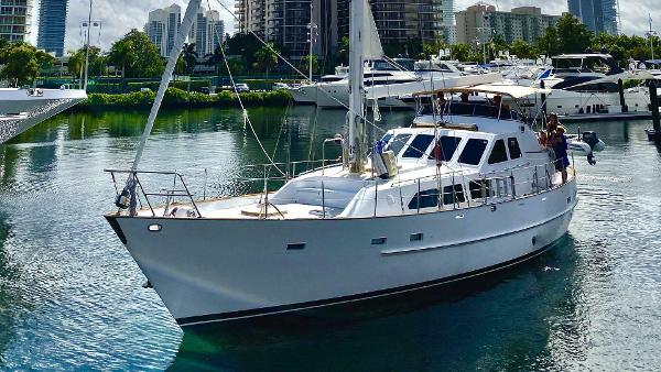 Cheoy Lee Sloop 1990 Cheoy Lee Sloop sailing in a marina with city skyline background.