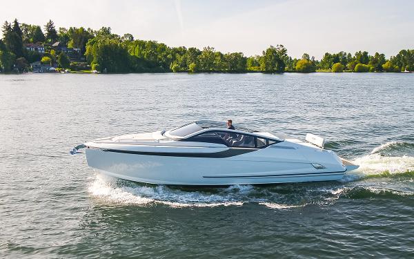 Fairline F//Line 33 2022 Fairline F//Line 33 yacht cruising on a serene lake with lush green surroundings.