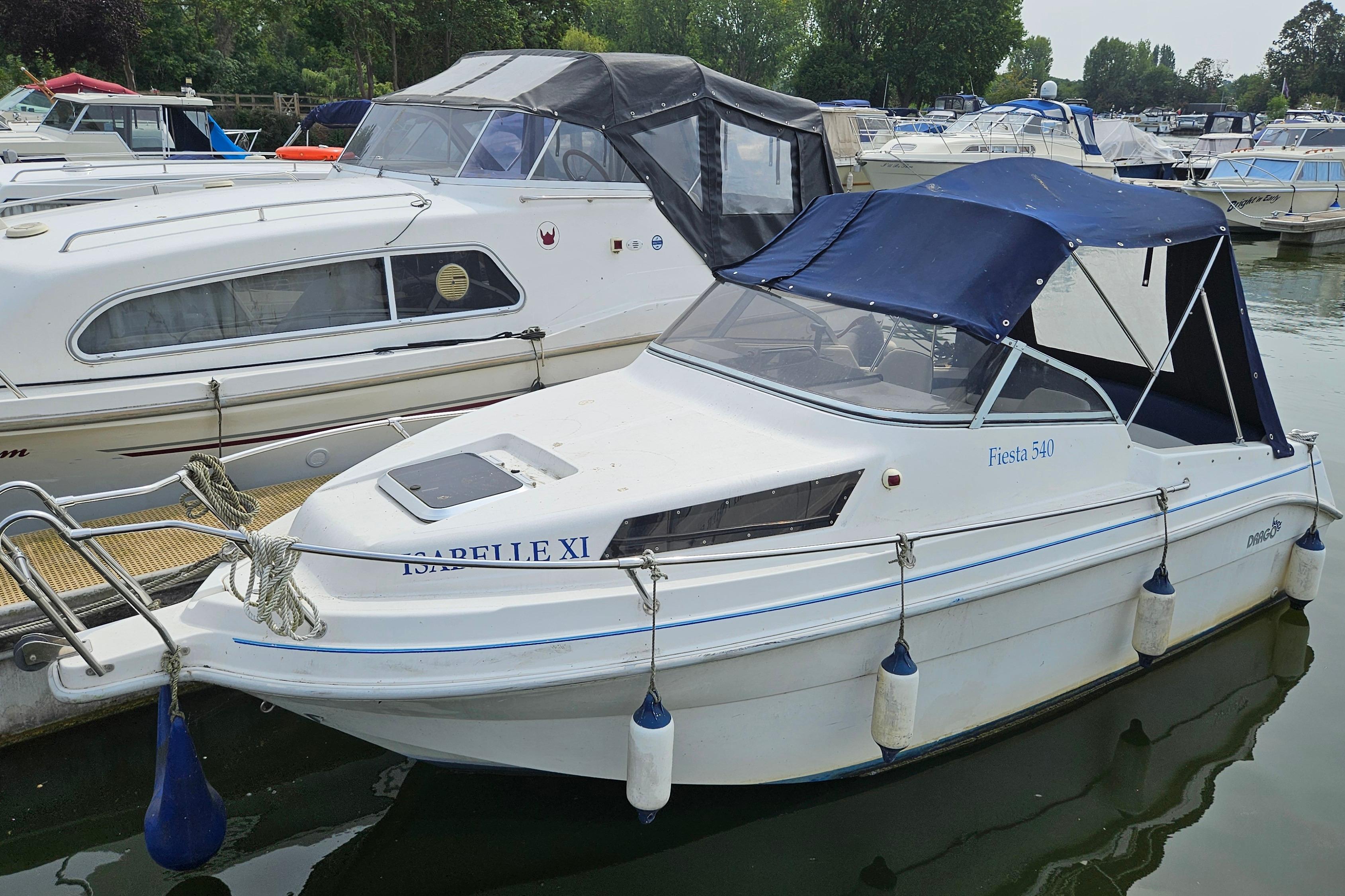 Drago Fiesta 540 2004 Drago Fiesta 540 boat docked at marina with blue canopy.