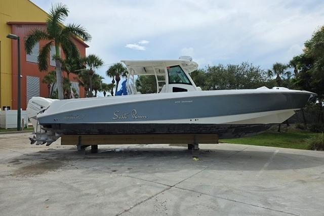 Boston Whaler 370 Outrage 2015 Boston Whaler 370 Outrage boat on display, surrounded by palm trees.