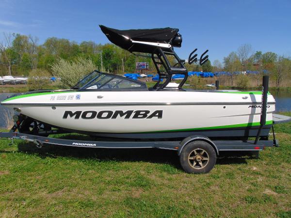Moomba Mondo 2018 Moomba Mondo boat on trailer, white with green accents, parked on grass.