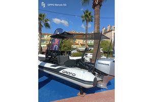 Grand D600 Lux 2024 Grand D600 Lux boat with Honda engine displayed outdoors under clear blue sky.