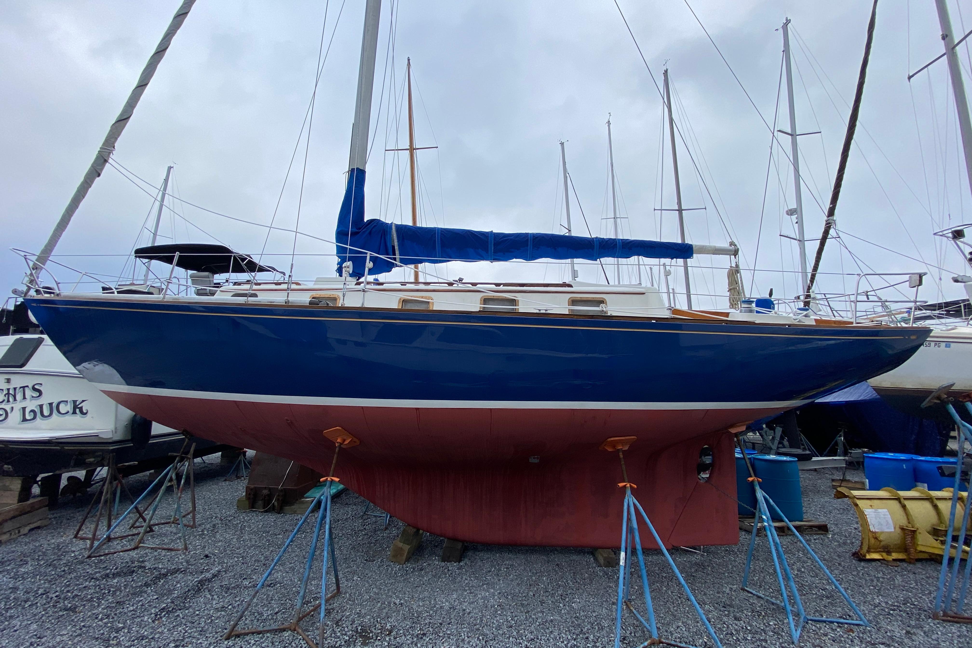 Bristol 40 1972 Bristol 40 sailboat on stands, blue hull, red keel, marina setting.