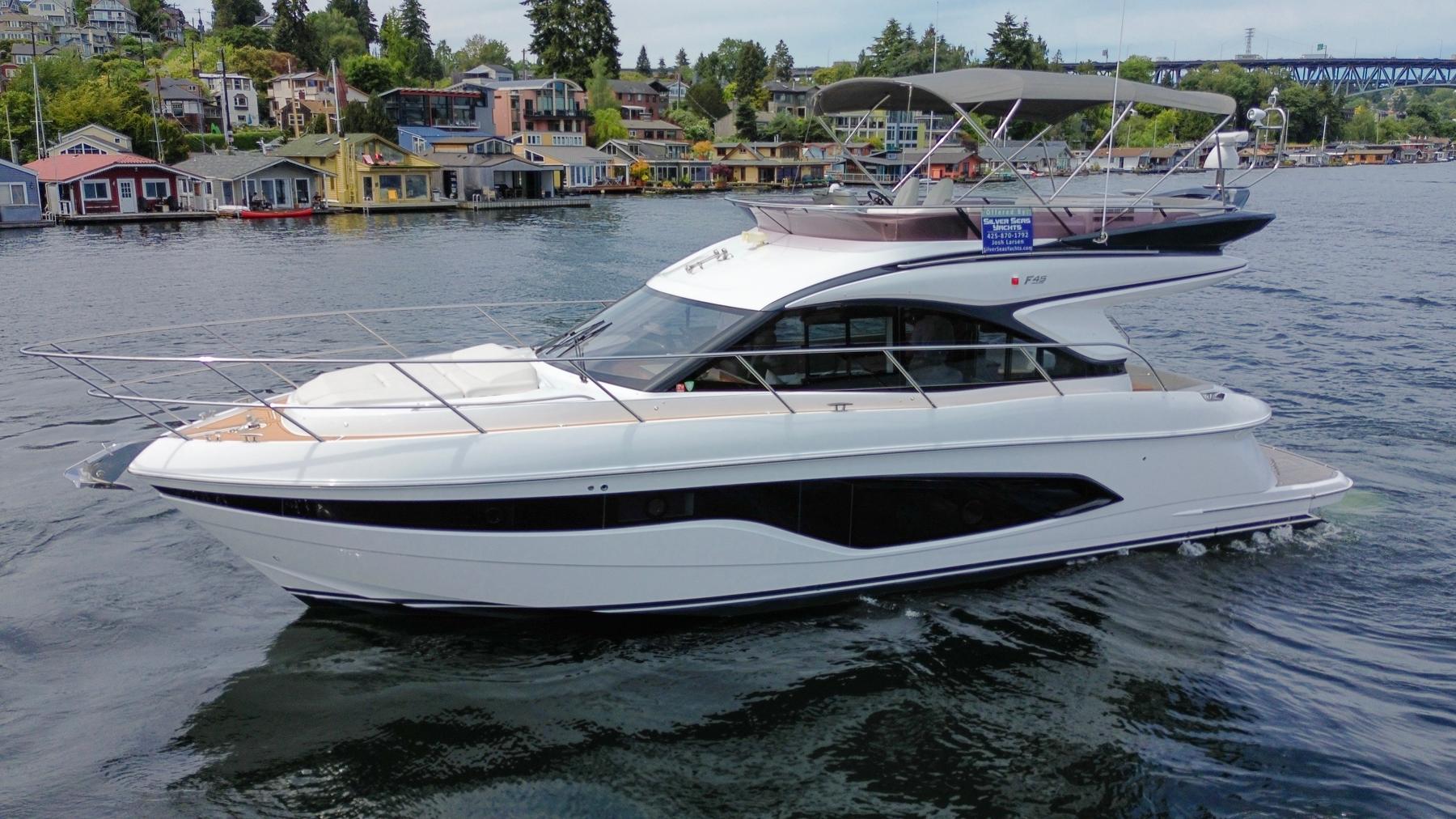 Princess F45 Luxury 2020 Princess F45 yacht cruising near colorful waterfront homes.