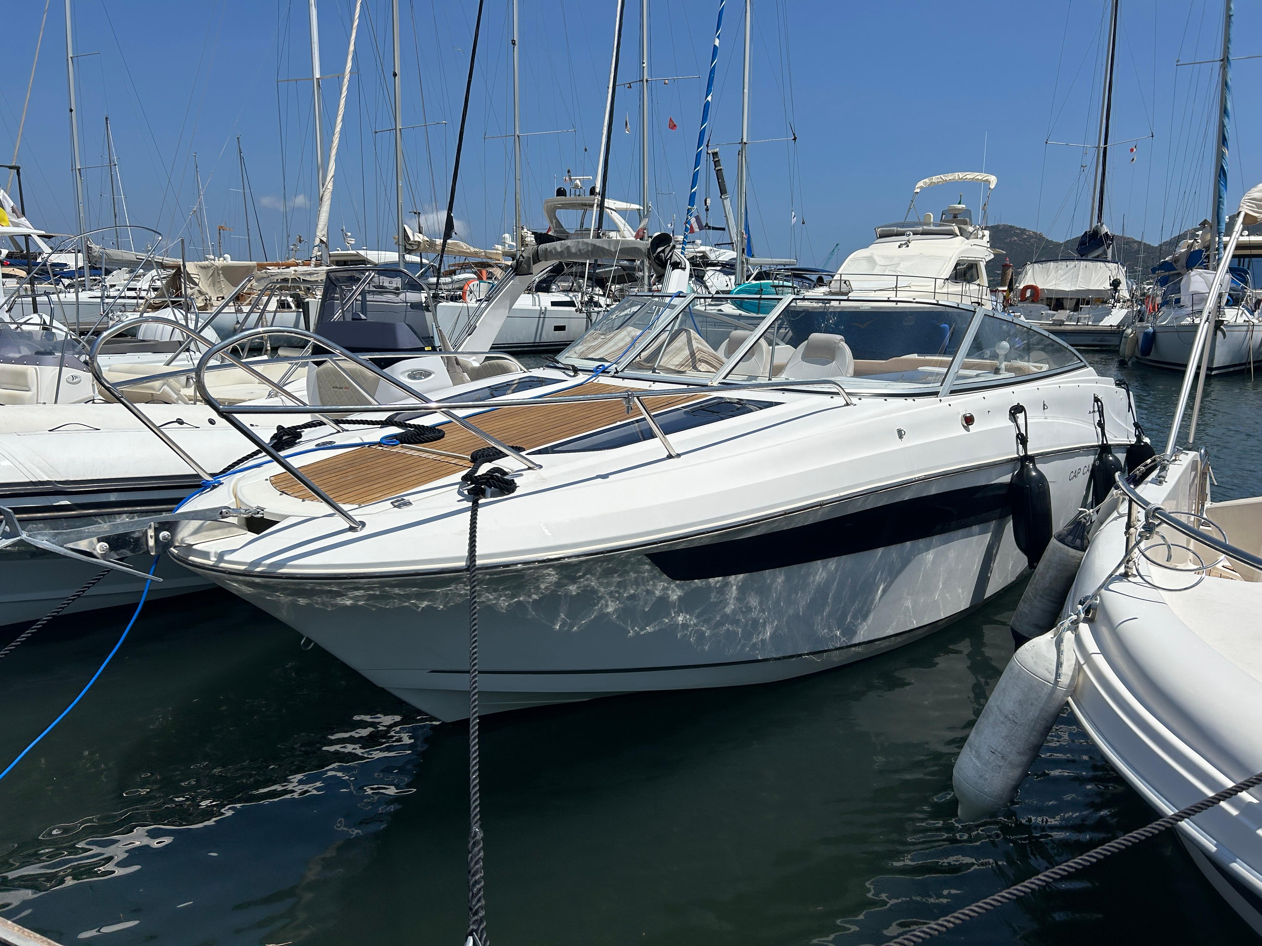 Jeanneau Cap Camarat 7.5 DC Jeanneau Cap Camarat 7.5 DC 2010 boat docked in a marina, surrounded by other vessels.