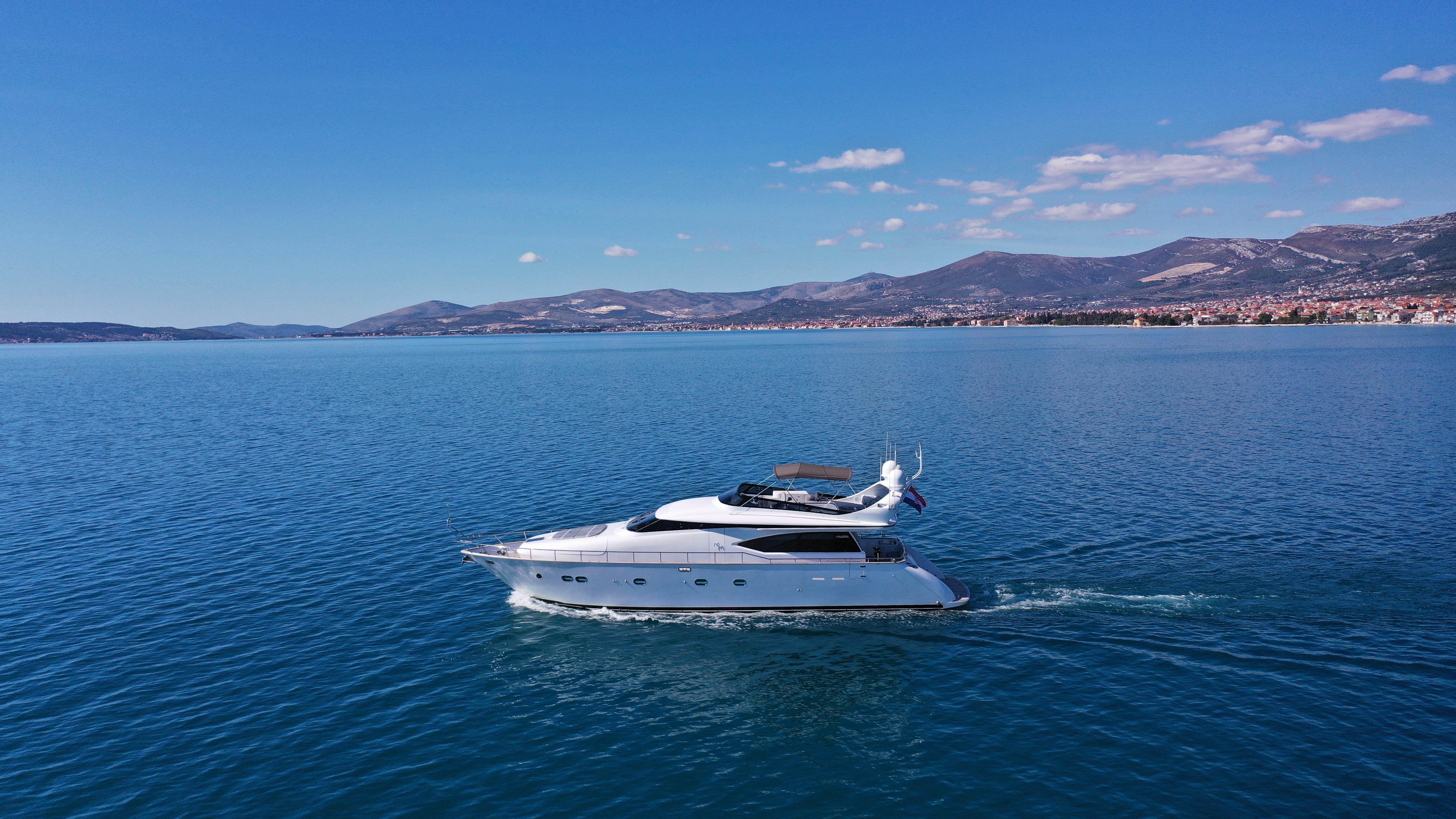 Maiora 20S Maiora 20S 2008 yacht cruising on a serene blue sea with mountains in the background.