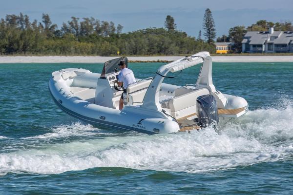 Orca Pro Marine 26 2023 Orca Pro Marine 26 boat cruising on clear blue water near a sandy shoreline.