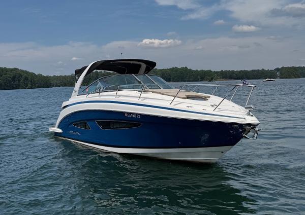 Regal 32 Express 2014 Regal 32 Express boat on a calm lake under a partly cloudy sky.