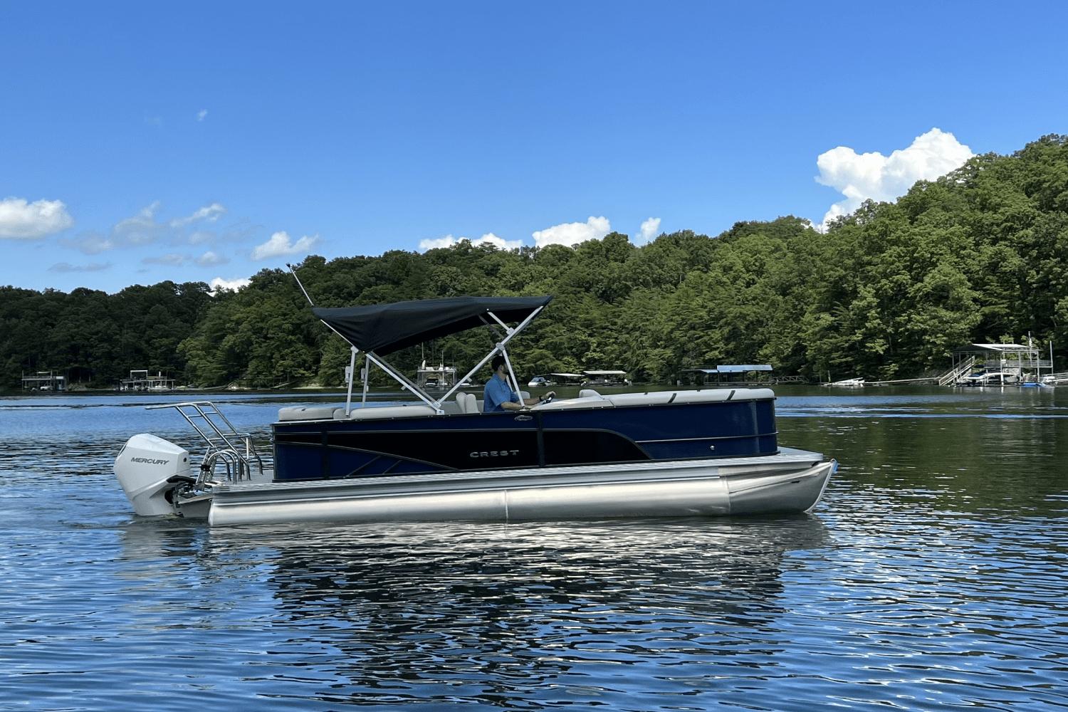 Crest Classic DLX 220 2023 Crest Classic DLX 220 pontoon boat on a serene lake.